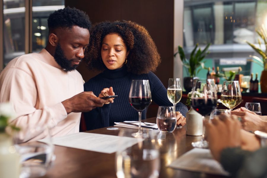 Young,Couple,Ordering,On,Phone,In,Wine,Bar